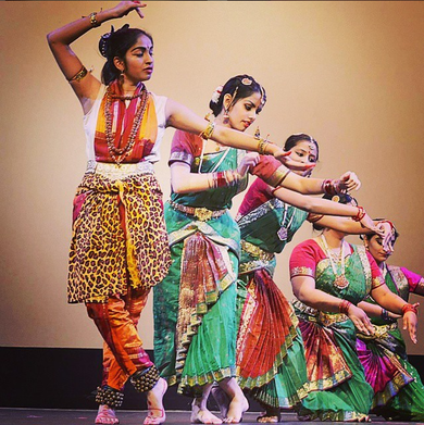 Four Indian dancers in performance attire posing during a Southern Indian dance.